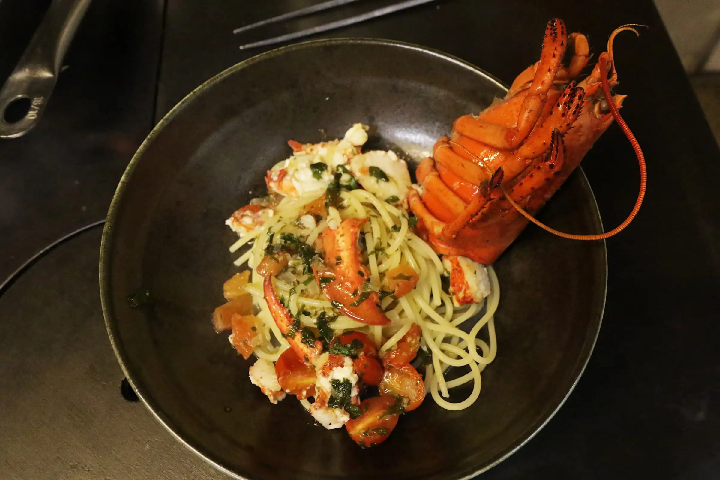 Homard entier servi sur un nid de spaghetti