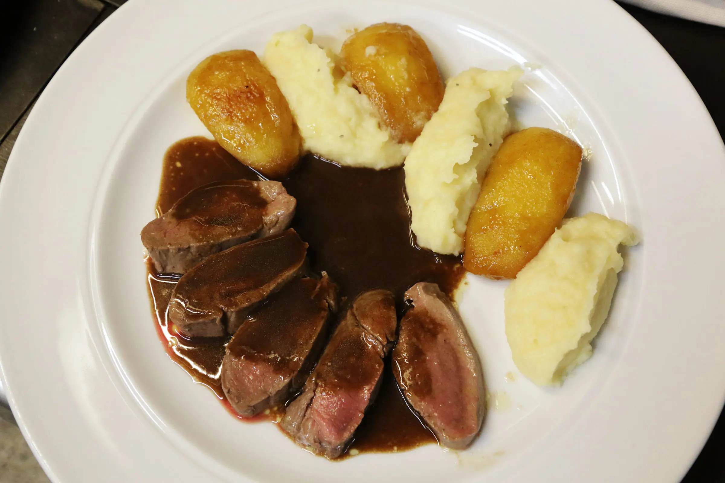 Filet en tranches, sauce corsée et pommes rissolées